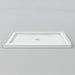 White Acritec low profile single threshold shower base with center drain in a modern alcove installation